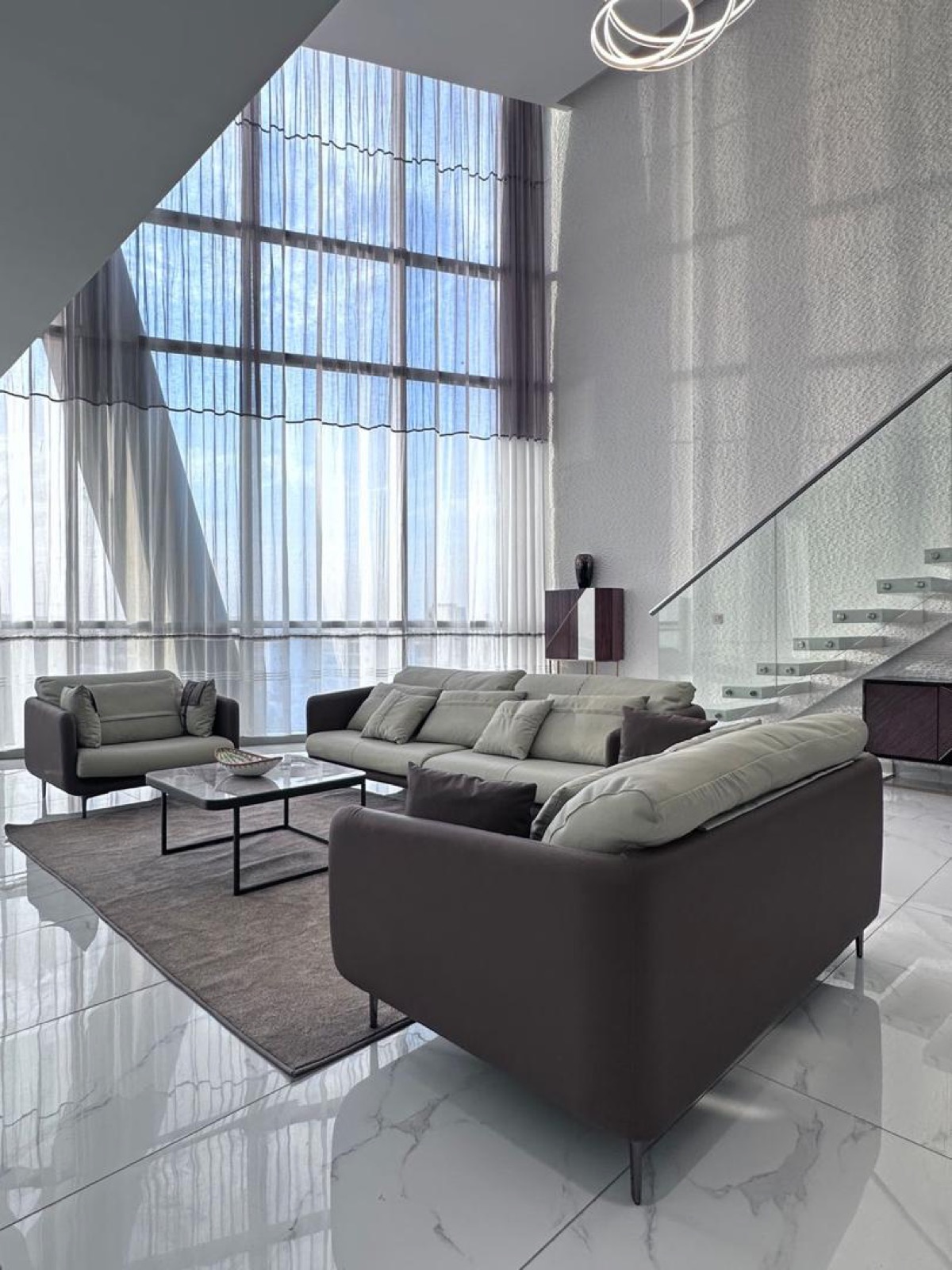 Photo — séjour du duplex, double hauteur et escalier de verre